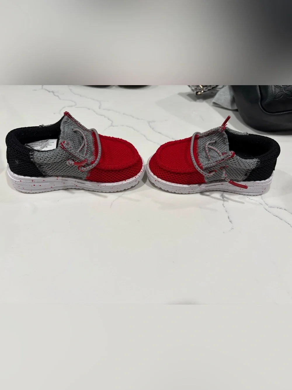 Hey Dude Kids Red and Gray Slip-On shoes.